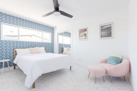 Calm bedroom w/ crisp bedding, playful wallpaper & natural light for easy, restful nights.