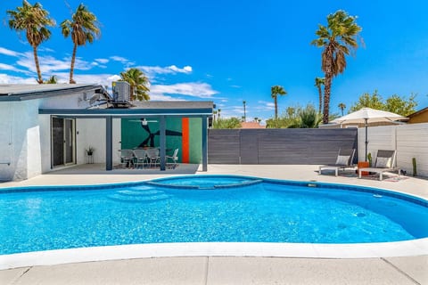 Sunlit pool & sleek desert architecture create a refreshing outdoor escape perfect for laid-back days.