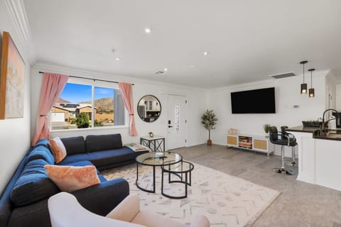Bright, open living room w/ comfy seating, wall-mounted TV & easy flow to the rest of the home.