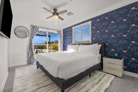Cozy bedroom w/ bold accent wall, soft bedding & a calm setup for restful nights.