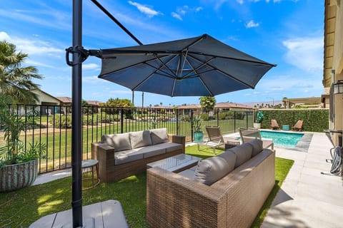 Shaded outdoor lounge w/ cushioned seating, ideal for relaxing & casual conversations.
