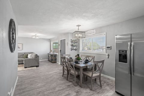 Open dining area w/ modern table set beside the kitchen, ideal for shared meals & conversation.