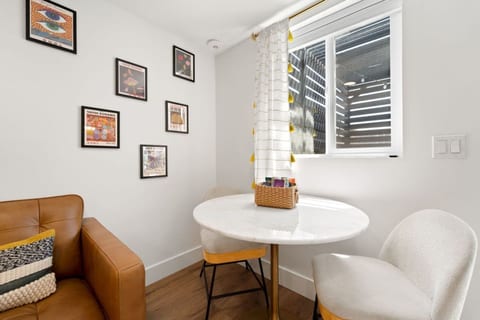 Intimate dining nook w/ round table & cushioned chairs, ideal for coffee or casual meals.