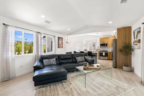Bright open living space w/ comfy seating flowing into the kitchen, ideal for gathering after a day outside.