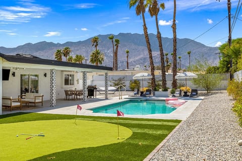 Sun-soaked pool & patio framed by palms and mountain backdrops, setting the scene for laid-back desert days.