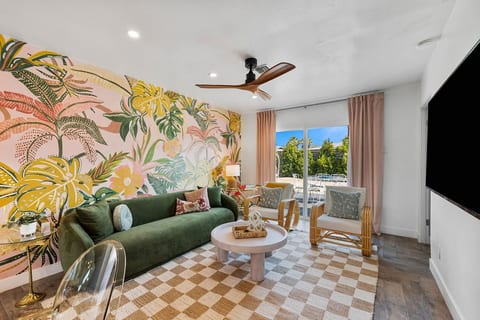 Bright living room w/ playful murals, comfy seating & easy flow to the outdoors.