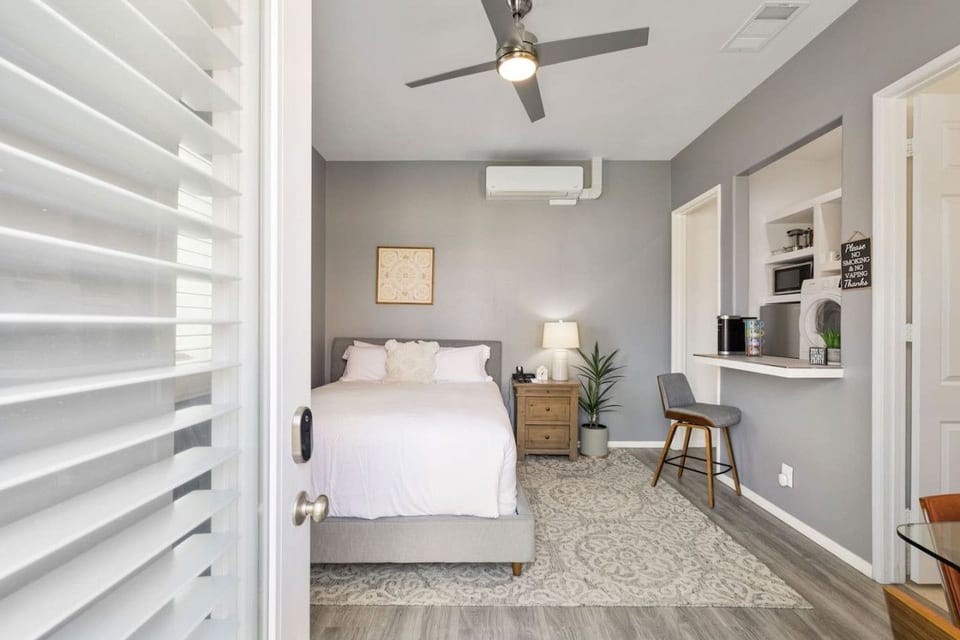 Bright home office setup w/ desk & shelves, ideal for focused work or trip planning.