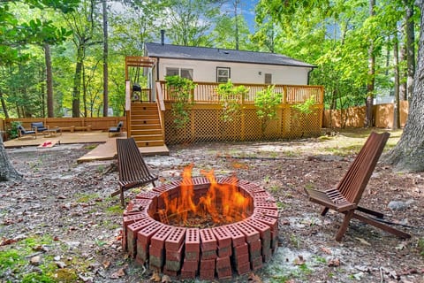 Inviting backyard firepit surrounded by trees, perfect for evening chats and s’mores.