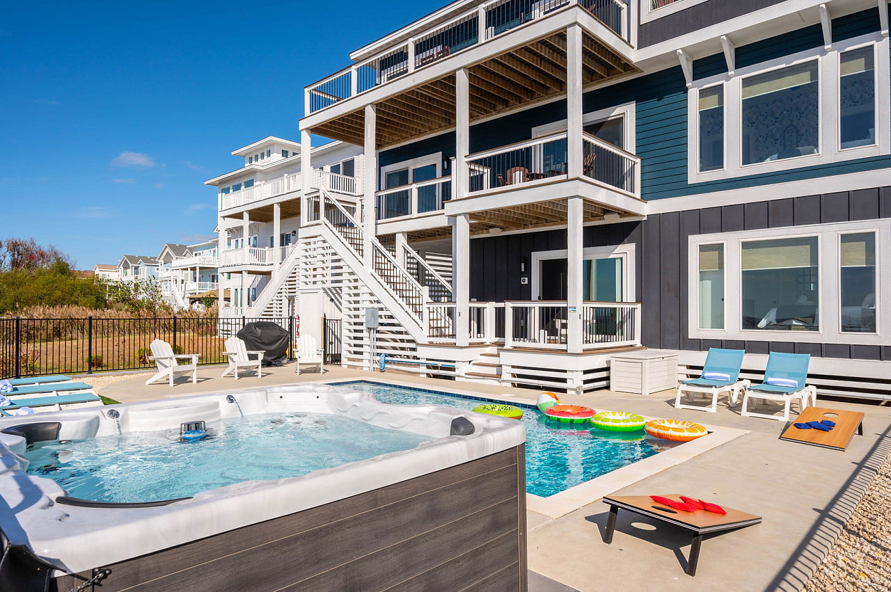 Resort-style pool & sun loungers framed by bold coastal architecture, perfect for laid-back days in the sun.