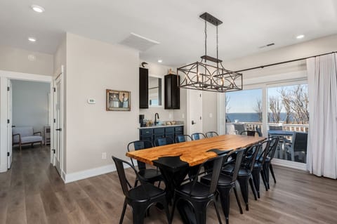 Stylish dining area w/ long table & modern lighting, perfect for shared meals & easy conversation