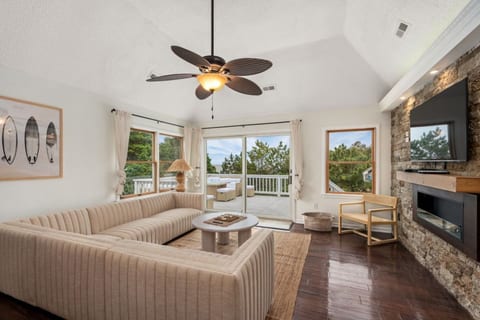 Bright living room w/ comfy seating, ceiling fan & easy flow to the outdoors.
