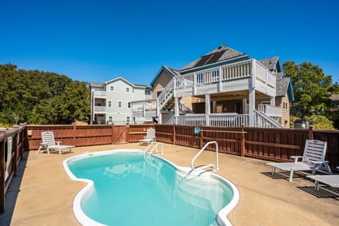 Sunlit backyard pool w/ fenced yard, perfect for cooling off after a day of coastal adventures.