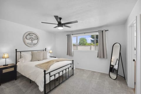 Bright bedroom w/ ceiling fan, plush bedding & a calm setup for restful nights.