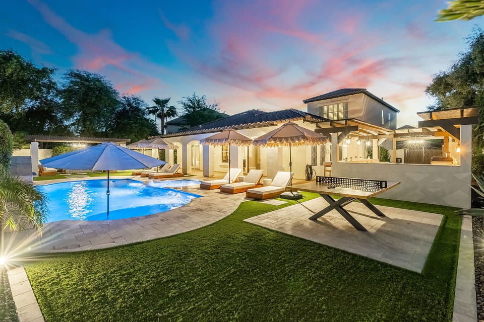 Beautifully lit exterior showcasing the home’s architecture against the evening sky