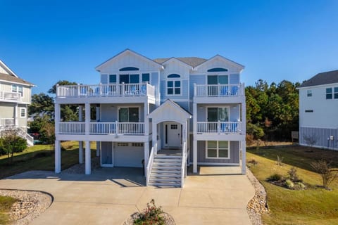 Elevated beach house exterior w/ wide stairs & classic coastal charm