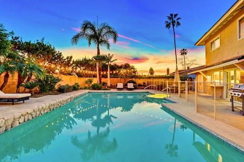 Sparkling backyard pool at sunset w/ lounge seating & palm-lined ambiance for relaxing evenings outdoors