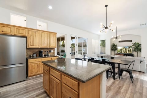 Roomy kitchen w/ granite island, stainless appliances & clear sightlines to the dining table.