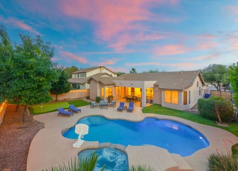 Pool & raised spa glowing at dusk w/ loungers set out for late-evening swims.