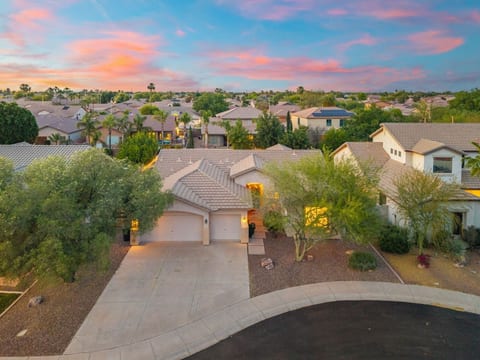 Front exterior at sunset w/ desert landscaping & a wide driveway for easy parking.