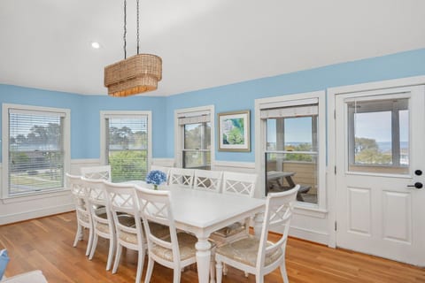 Sun-filled dining area w/ seating for the whole group, wrapped in soft blue tones & natural light.