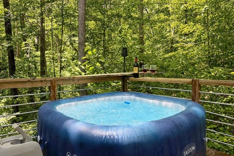 Unwind outdoors with three levels of private decks featuring an outdoor TV, cozy daybed, string lights, and forest views. Perfect for evening movies, morning coffee in the trees, and relaxing moments surrounded by nature