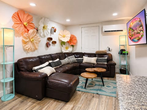 Cozy living room with a plush leather sectional and 60” Smart TV—perfect for relaxing or game nights. Enjoy a Nintendo Wii with 4 controllers and classic games, creating a fun, family-friendly space to unwind after exploring Stone Mountain.