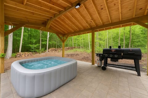 A private outdoor retreat tucked in the trees—soak in the hot tub beneath the gazebo, grill under the open sky, and unwind in peaceful Smoky Mountain surroundings designed for total relaxation.