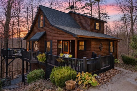 Cozy woodland cabin with wraparound deck and glowing sunset views