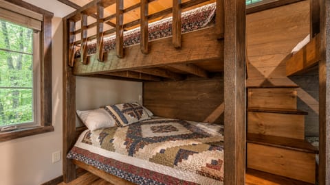 Rustic cabin bunk room with cozy quilts and space for family or friends