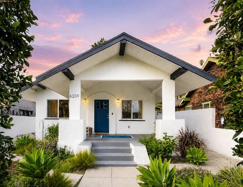 Charming bungalow entry with lush landscaping and inviting front porch