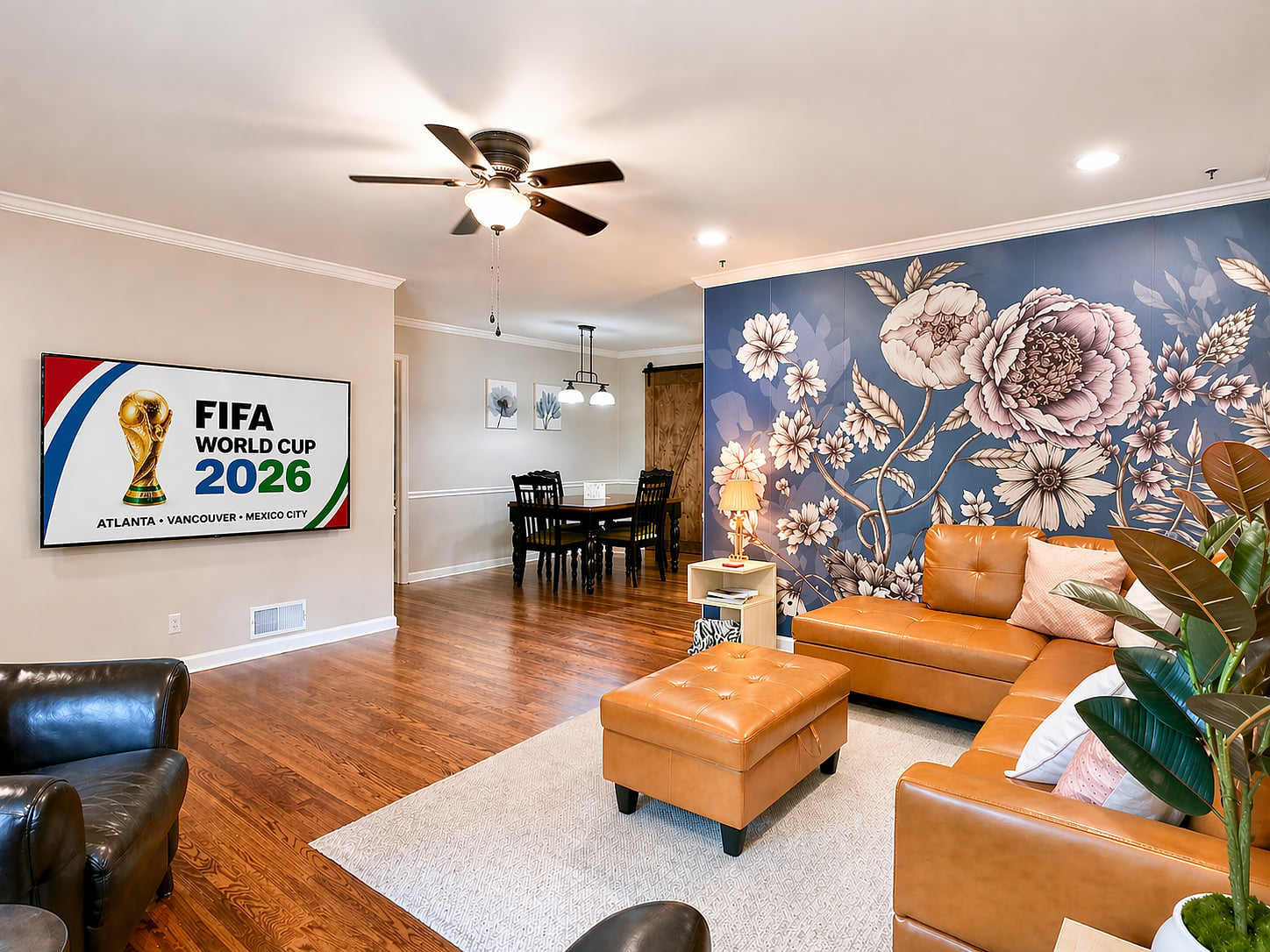 Stylish open living with floral accent wall, leather sofa, and smart TV