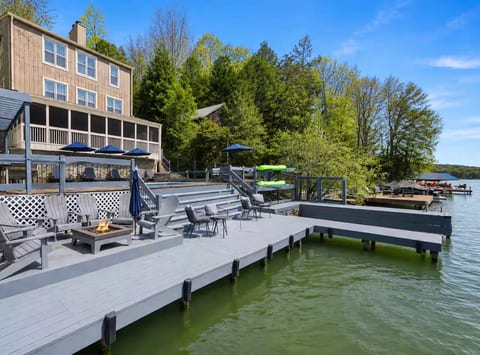 Expansive lakefront deck with fire pit, seating, and direct water access