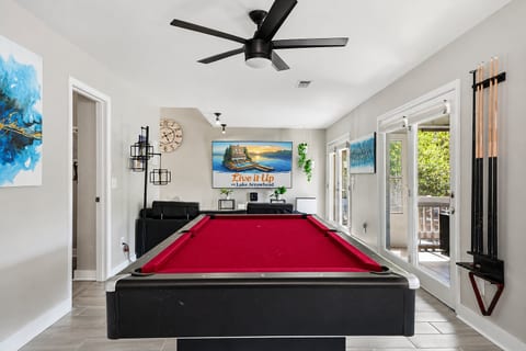 Bright game room with pool table, lounge seating, and outdoor access