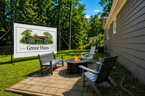 Private patio with fire pit, Adirondack seating, and wooded backyard