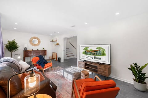 Bright, stylish living room with cozy seating and large TV