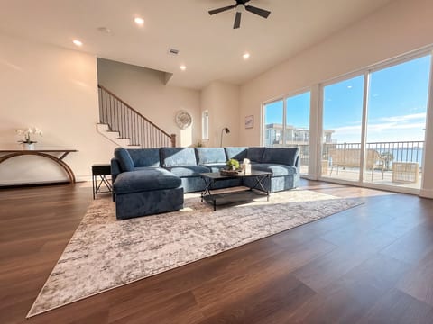 Bright open living room with large sectional and balcony water views