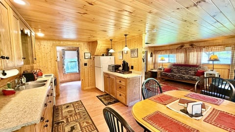 Cozy open-concept living, dining, and kitchen space filled with warm cabin charm.