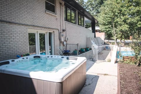 Exclusive Hot Tub Nestled at the Rear of the House, Adjacent to a Private Fenced Pool for Your Convenience.