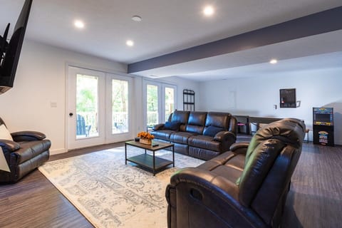 The lower level also has an open floor plan with a sitting area to watch TV or enjoy the fireplace. The other half of the room is the game area with a 9' shuffleboard table and a Street Fighter arcade cabinet.