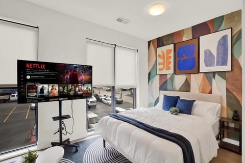 Bright modern bedroom with bold accent wall and in-room Netflix TV