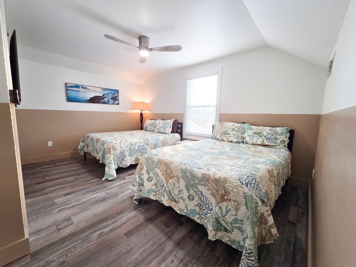 4th Bedroom with two Queens size memory foam mattresses, 65" Samsung Smart TV, Night stand w/power strips for hungry phone chargers, ample closet space and window view of pool.