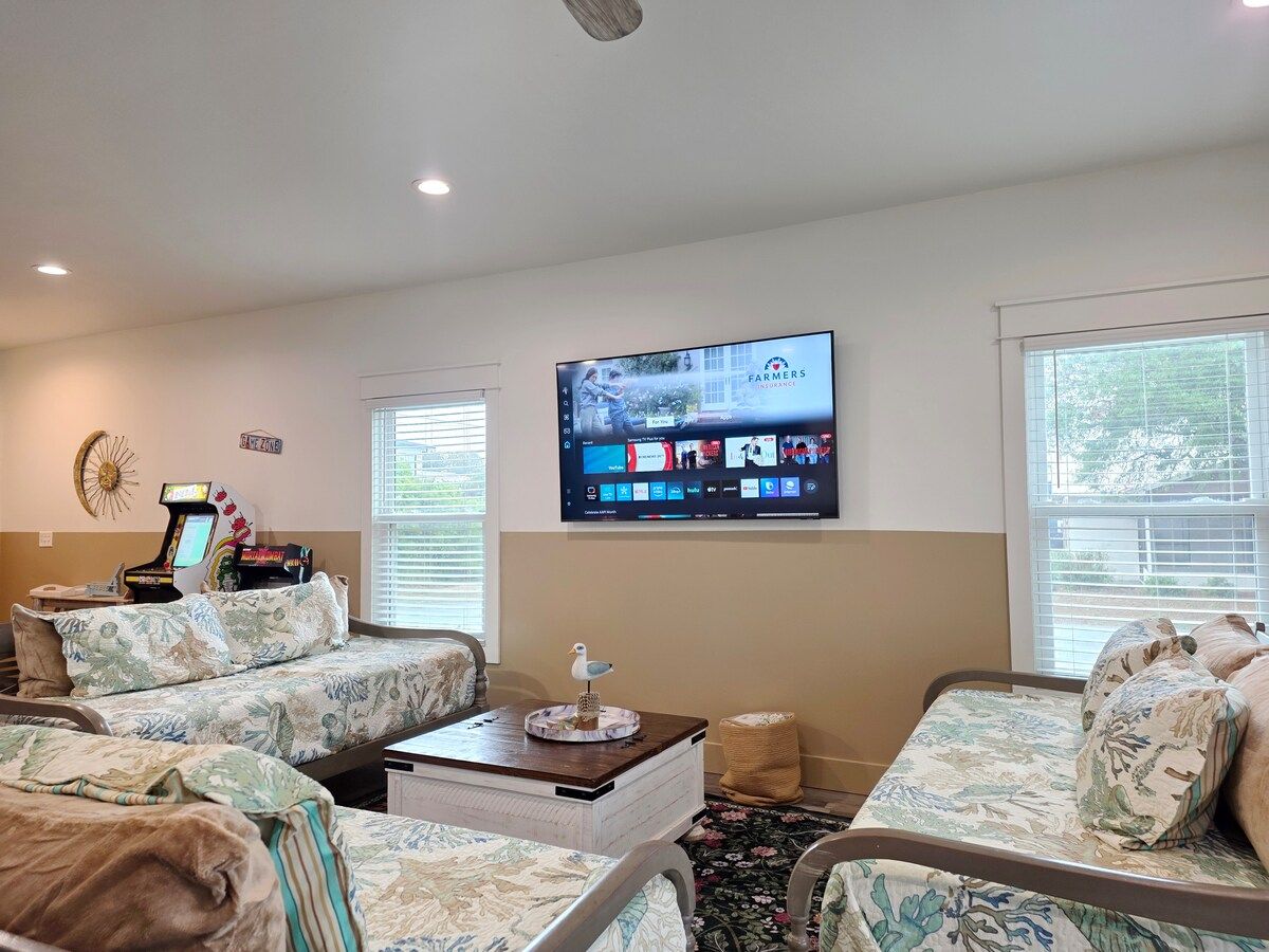 Living Room has 2 gaming systems w/ 3 twin size Day Beds, coffee table, with 70" Samsung Smart TV, and large dining table.