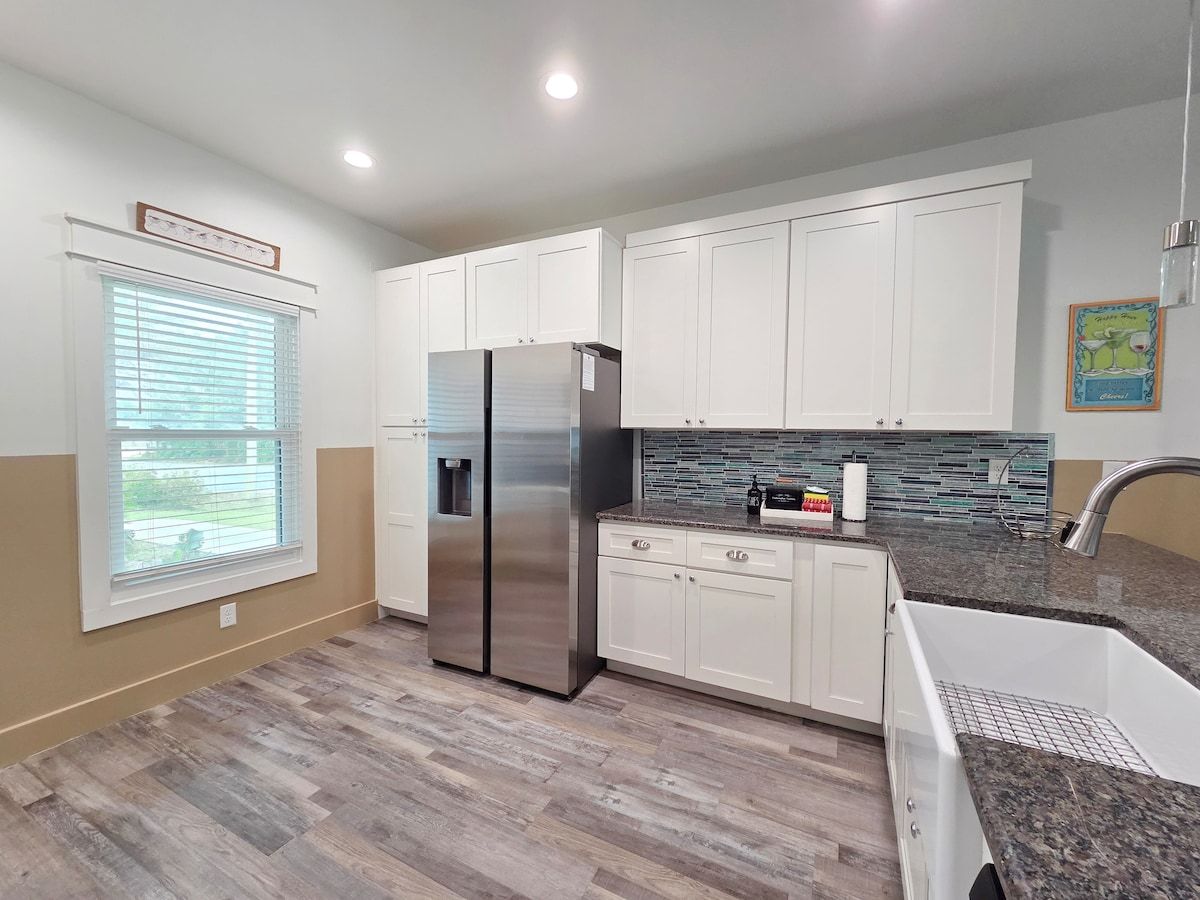 Kitchen w/ all new Stainless Steel appliances including a dishwasher, microwave, coffee maker, blender, and toaster. Room at the bar to sit and enjoy a snack or eat any meal.