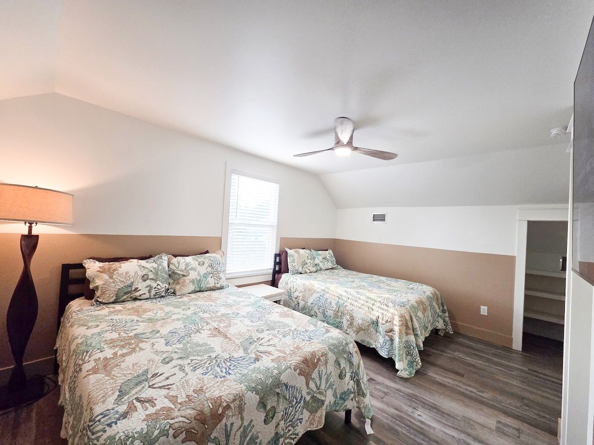 4th Bedroom with two Queens size memory foam mattresses, 65" Samsung Smart TV, Night stand w/power strips for hungry phone chargers, ample closet space and window view of pool.