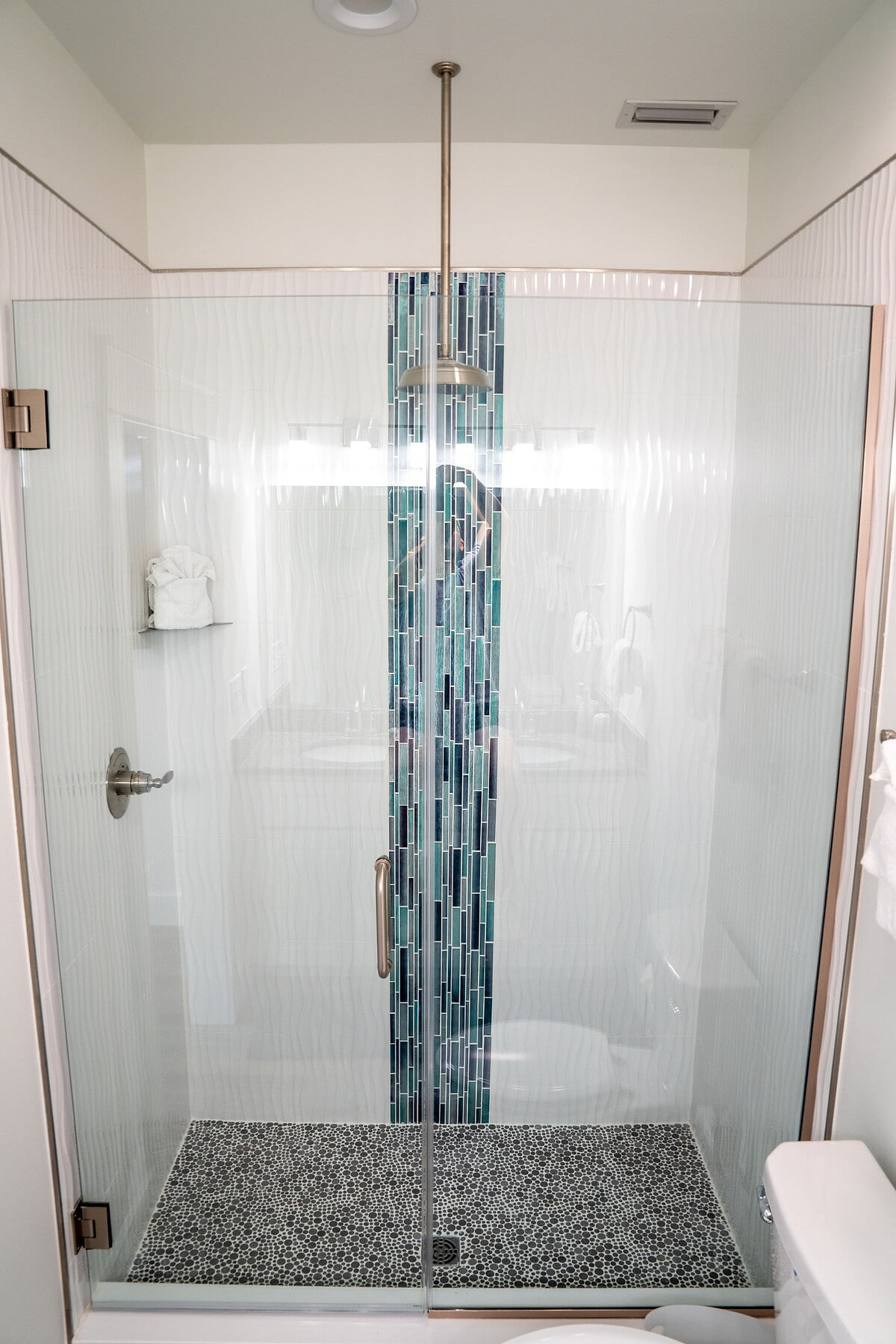 Master Bath with walk in shower and water fall shower head, double vanities, toilet, and ample cabinet space for storage.