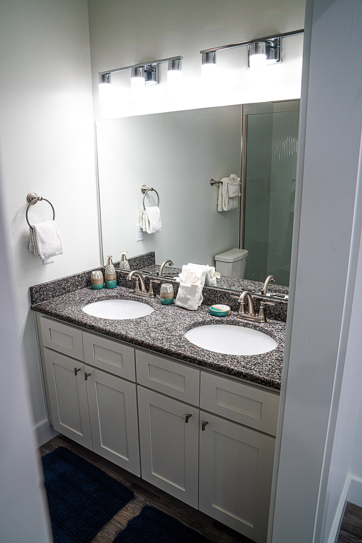 Master Bath with walk in shower and water fall shower head, double vanities, toilet, and ample cabinet space for storage.