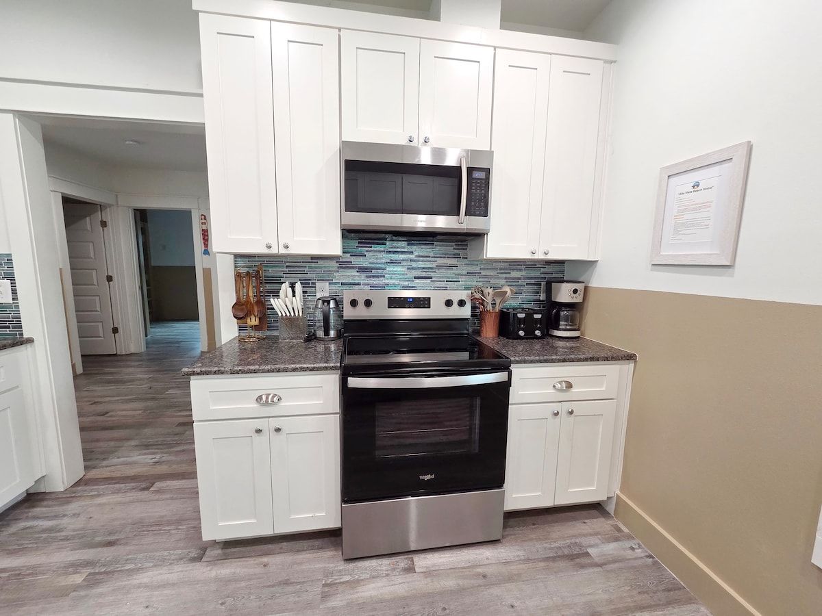 Kitchen w/ all new Stainless Steel appliances including a dishwasher, microwave, coffee maker, blender, and toaster. Room at the bar to sit and enjoy a snack or eat any meal.