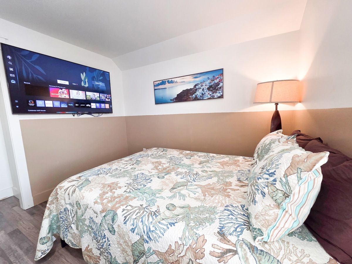 4th Bedroom with two Queens size memory foam mattresses, 65" Samsung Smart TV, Night stand w/power strips for hungry phone chargers, ample closet space and window view of pool.