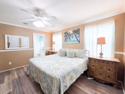 Master Bedroom with King Size Bed, ceiling fan, night stands with lamps and power strips for electronic devices, and a 55" Samsung Smart TV w/ rear LED lighting.