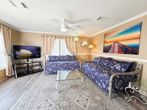 Living Room with 2 twin size Day Beds, Ceiling Fan, power strips for electronic devices, and 55" Samsung Smart TV w/ rear led lighting